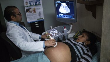 A poster with information about the Zika virus hangs on a wall as a pregnant woman undergoes an ultrasound treatment at the Social Security Institute maternity ward in Guatemala City, Guatemala.