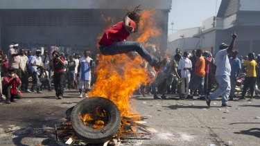 A protester jumps over a burning barricade in the capital.