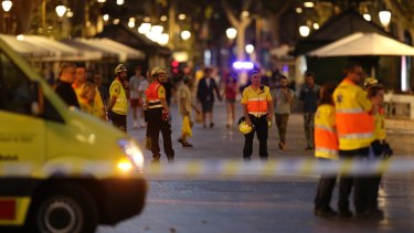 Emergency workers stand on a blocked street in Barcelona, Spain, Thursday, Aug. 17, 2017. A white van jumped up onto a sidewalk and sped down a pedestrian zone Thursday in Barcelona's historic Las Ramblas district, swerving from side to side as it plowed into tourists and residents. Police said 13 people were killed and more than 50 wounded in what they called a terror attack. (AP Photo/Manu Fernandez)