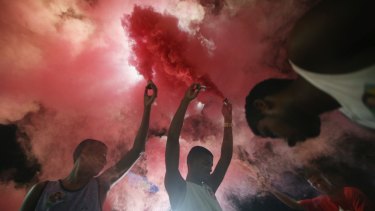 Anti-impeachment protesters light red smoke, the colour of the Workers' Party, in Rio de Janeiro.
