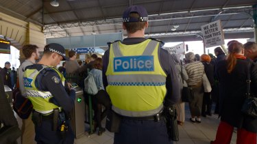 Police watch as protesters rally inside Flinders Street Station on August 28 against    Australian Border Force officers taking part in Operation Fortitude.