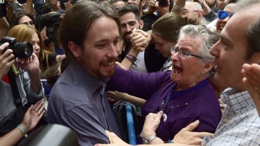 A woman hugs anti-austerity leader Pablo Iglesias as they celebrate Manuela Carmena's victory.