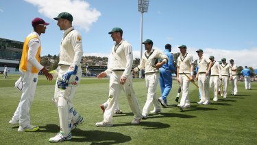  Australian players shake hands with West Indies players at the end of the first Test in Hobart on Saturday. 