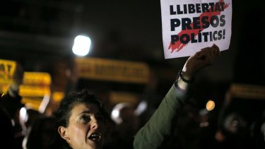 A woman holds a sign in Catalan reading: "Freedom for the political prisoners" outside the Catalonian Parliament in Barcelona on Thursday to protest against the decision of a judge to jail former members of the Catalan government.