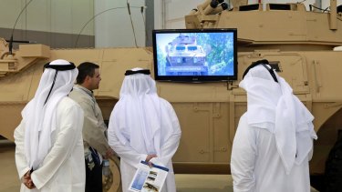 Visitors at the 2011 IDEX arms fair in Abu Dhabi, the United Arab Emirates, watch a promotional video for the M1117 armoured vehicle, manufactured by Textron Systems.