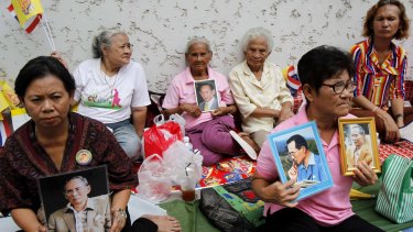 Well-wishers hold portraits of the king as they wait for him to leave hospital in  2013.