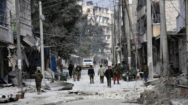 Syrian soldiers and civilians marching through the bomb-damaged streets of east Aleppo.