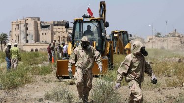 An Iraqi forensic team in the city of Tikrit works at the site of a mass grave, believed to contain the bodies of Iraqi soldiers massacred by the so-called Islamic State in June.
