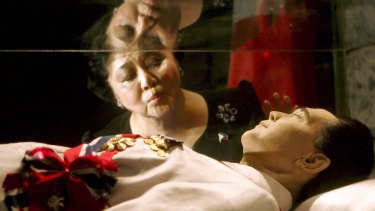 Imelda Marcos kisses the refrigerated crypt of her husband, the late strongman Ferdinand Marcos on his 88th birthday in 2005.