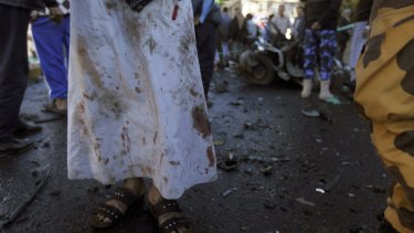 A doctor with blood on his clothes stands at the scene of the attack.