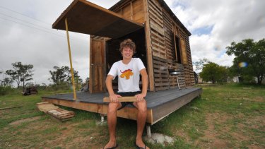 Angus Hughes with the prototype pallet house he built outside Rockhampton over five months.