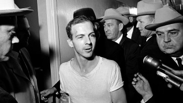 Lee Harvey Oswald talks to the media as he is led down a corridor of the Dallas police station for another round of questioning in connection with the assassination of John F. Kennedy.