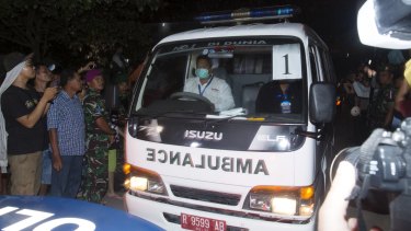 An ambulance leaves Cilacap carrying a coffin.