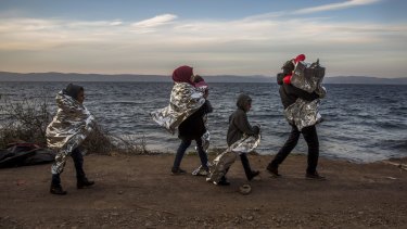 A Syrian family covered with thermal blankets walk after they arrived from Turkey at the Greek island of Lesbos in October.