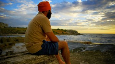 Tourist Parminder Singh from India watches the sun rise at Clovelly Beach on Tuesday morning.
