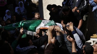 Palestinian mourners carry the body of Abdallah Shalalda, killed in the raid, at his funeral.