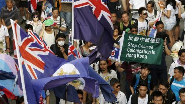 Protesters carry Hong Kong colonial flags and anti-China placards during a march in Hong Kong on July 1, 2015, the day marking the 18th anniversary of Hong Kong's handover from Britain to Chinese sovereignty. 