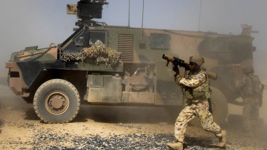 An Australian soldier dismounts an Australian-made Bushmaster armoured personnel carrier in Afghanistan. The vehicles, made in Bendigo, are being exported.
