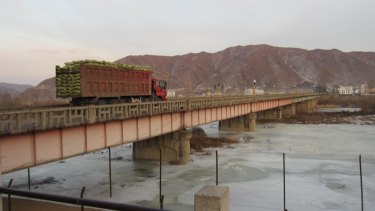 Hard land: A loaded truck crosses the Tumen River from China into North Korea.