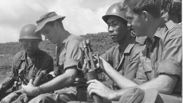 Australian soldiers Private Greg Salmon (left) and Private John Dever show their South Vietnamese allies their weapons in Phouc Tuy province in 1969.