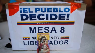 A image of Virgin Mary decorates the front of a box that reads in Spanish "The People decide, table 8" at a poll station in Caracas.