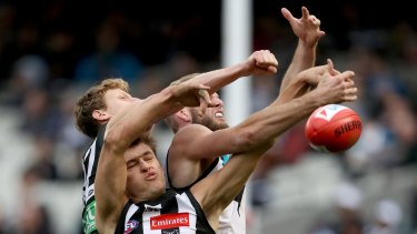 Collingwood's Darcy Moore tangles with Port Adelaide's Jackson Trengove.