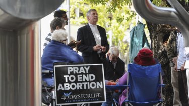 Catholic Archbishop of Canberra and Goulburn Christopher Prowse, centre, attends a prayer vigil outside the Moore Street abortion clinic before an exclusion zone was established in 2016.