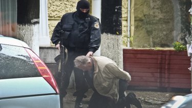 Teodor Chetrus is detained by a police officer in Chisinau, Moldova during the uranium-235 sting operation in 2011.