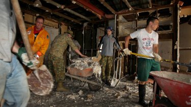 Members of the Mud Army clear a flood-affected home in Fig Tree Pocket.