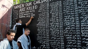 Palestinian youths in Bethlehem list the names of the children killed in Israel's Operation Protective Edge military assault on the Gaza Strip in July 2014.