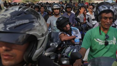 Nepalese motorists wait for their turn to fill their motorbikes at a fuel pump run by the Nepalese army in Kathmandu, Nepal on Monday.
