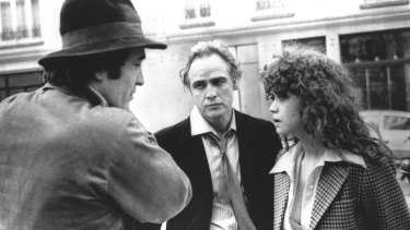 In this 1972 file photo originally provided by United Artists, director Bernardo Bertolucci, left, Marlon Brando and Maria Schneider are shown during the filing of <em>Last Tango in Paris</em>.