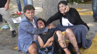 Wounded people wait for help at the site of the explosion in Ankara.