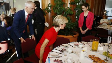 Prime Minister Malcolm Turnbull pulls the chair out for Minister for Foreign Affairs Julie Bishop during the International Women's Day 2017 Parliamentary breakfast at Parliament House on Thursday.