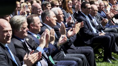 Members of Trump's cabinet applaud as Trump announces his decision on the climate accord.