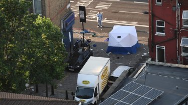 A police forensics officer examines the scene at Finsbury Park, where one person was killed and eight were injured in a van attack.