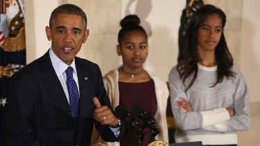 US President Barack Obama 'pardons the turkeys' as his daughters Sasha and Malia look on. 
