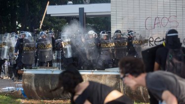 Protesters against President Michel Temer throw projectiles at police in Brasilia on Wednesday.