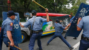 Police officers hit fleeing protesters during a violent dispersal outside the US embassy in Manila on Wednesday.