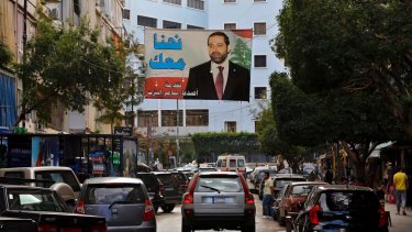 A poster of outgoing Prime Minister Saad Hariri hangs on a street in Beirut, Lebanon, on Monday.  The poster in Arabic reads, "We are with you."