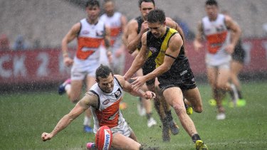 Wet 'n' wild: Phil Davis of the Giants (left) and Dan Butler battle it out during a mid-game downpour.