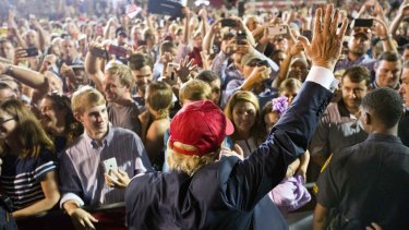 Republican presidential candidate Donald Trump waves to the crowd during a campaign pep rally in Mobile, Alabama.