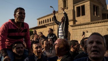 Christians rally outside the Church of St Peter and St Paul in Cairo, Egypt, after 27 people were killed by an explosion inside the church.