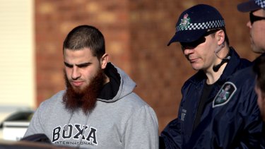 Hassan El Sabsabi, 23, is led away after the raid in Seabrook, Melbourne.