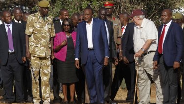 Kenya's President Uhuru Kenyatta, centre, looks on as 15 tonnes of ivory confiscated from smugglers and poachers is burnt in Nairobi National Park.
