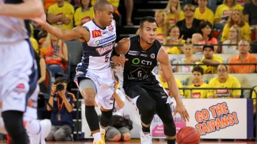 Melbourne United guard Stephen Holt holds off the advances of Markel Starks of the Cairns Taipans.