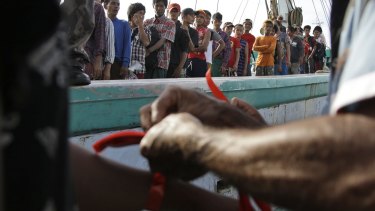 On April 4, Indonesian official put on wrist bands on recently rescued Burmese fishermen for identification purpose upon their arrival in Tual, Indonesia. 