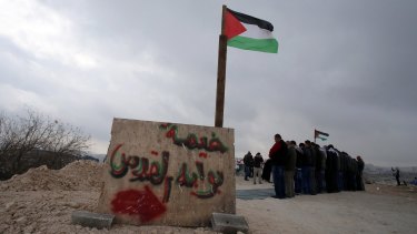 "Tent of Jerusalem's gate" is painted on a cement block during a protest on land that Palestinians say was confiscated by Israel for Jewish settlements. 