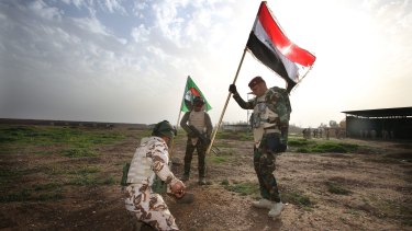 Iraqi soldiers plant the nation's flag at the range. 
