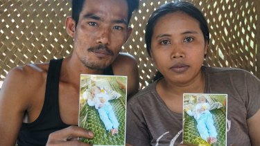 Nursah, left, and his wife Fatimah hold photos of their son Iqbal, who died at the age of three. Nursah worked in an illegal gold mine where he used mercury.